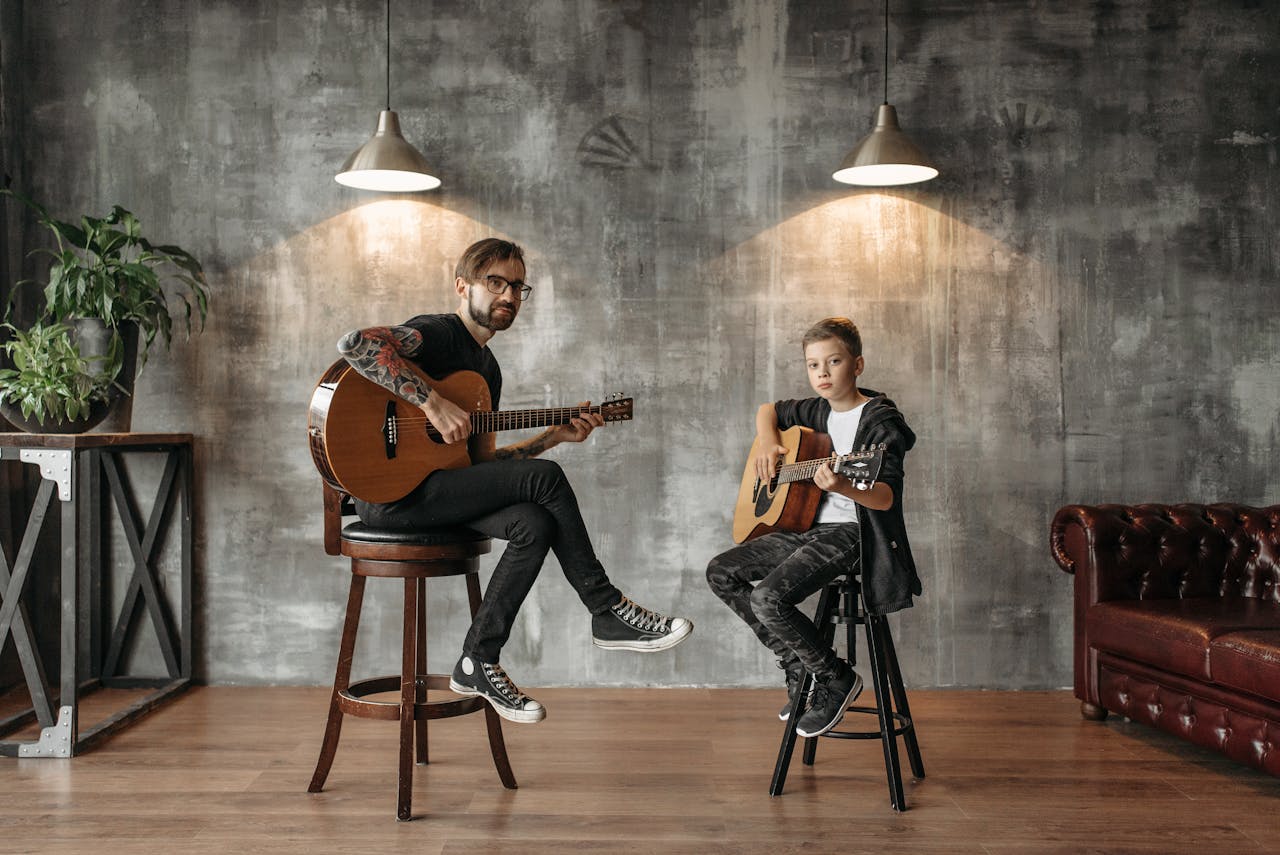 pexels-photo-7520927 A father and son enjoying a guitar lesson together in a stylish loft setting.